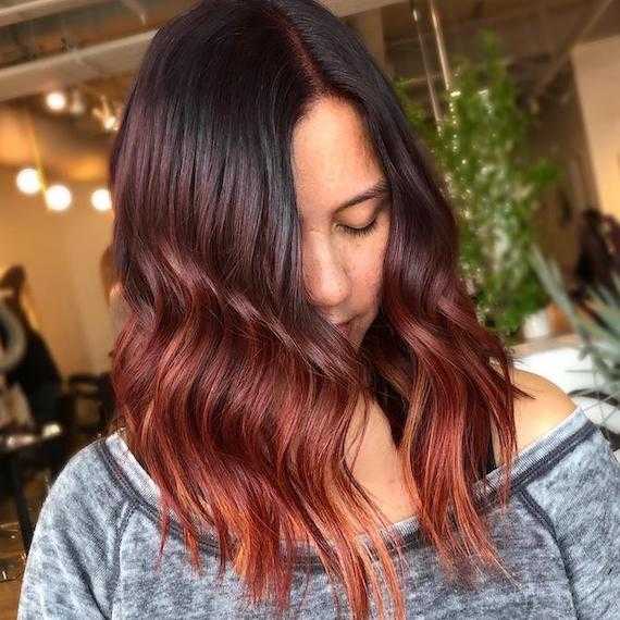 Photo of woman with wavy long bob and dark red ombre hair color, created using Wella Professionals.