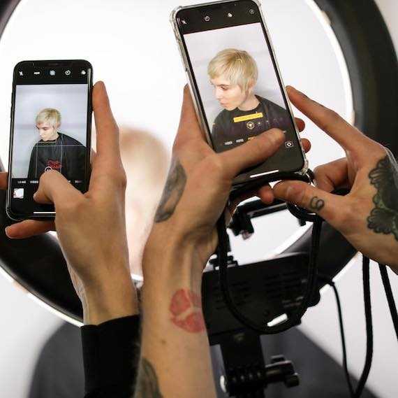 Photography ring light shown against a flower wall backdrop at a Wella Professionals event.